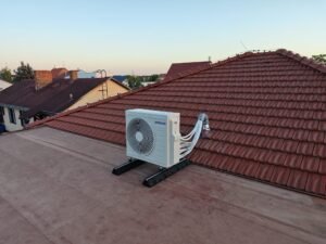upevněná klimatizační jednotka na střeše rodinného domu