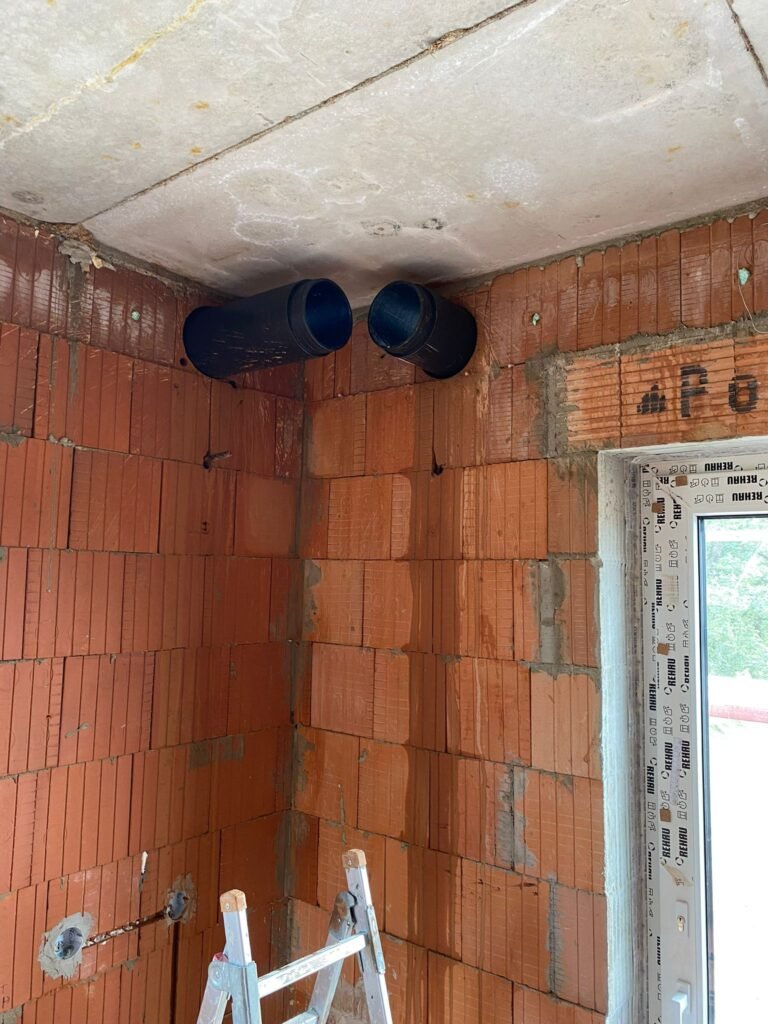 černé trubky na cihlové zdi